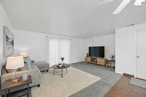 Virtually staged living area with new carpet and overhead fan