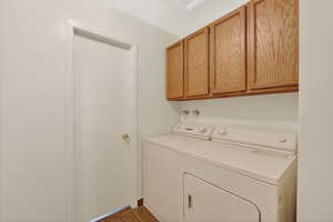 Laundry area upstairs with cabinet storage plus washer and dryer next to full bathroom