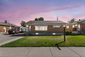 View of front of house featuring a front yard and brick siding