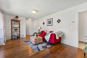 Living area featuring wood finished floors and a textured ceiling