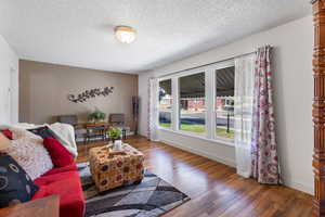 Living room with a textured ceiling and wood finished floors