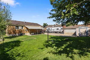 View of grassy yard with a storage unit