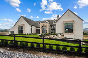 View of front of property featuring a fenced front yard, brick siding, a chimney, a mountain view, and stone siding