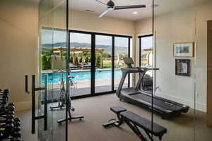 Exercise room with a mountain view, a ceiling fan, carpet, and recessed lighting