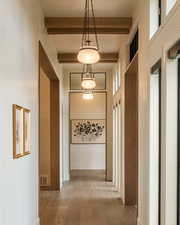 Hall featuring beamed ceiling, wood finished floors, and a towering ceiling