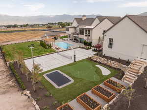 View of home's community with a swimming pool, a patio, a putting green, and a mountain view