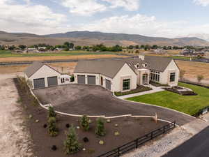 Modern farmhouse with driveway, a mountain view, a garage, and roof with shingles