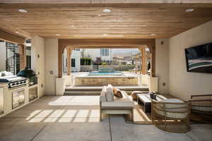 View of patio with exterior kitchen, an outdoor hot tub, and outdoor lounge area