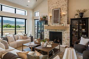 Living area featuring a fireplace, high vaulted ceiling, plenty of natural light, wood finished floors, and a mountain view