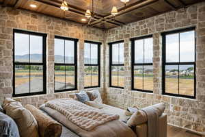 Bedroom featuring a wood ceiling with exposed beams, wood finished floors, and a mountain view