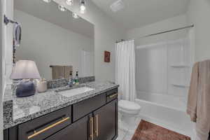 Bathroom with shower / tub combo with curtain and vanity
