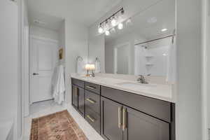 Bathroom featuring double vanity and light marble finish flooring