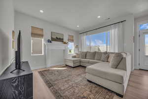 Living area with recessed lighting and light wood-style flooring