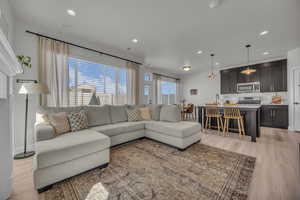 Living area featuring light wood finished floors and recessed lighting