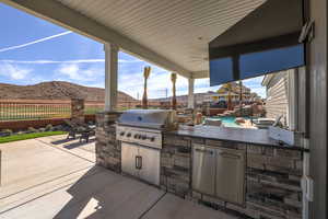Fenced backyard with a patio area and an outdoor kitchen