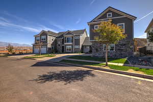 View of front of house featuring driveway, stone siding, and an attached garage