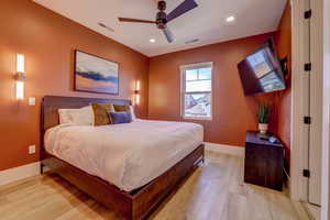 Bedroom featuring light wood finished floors, ceiling fan, and recessed lighting