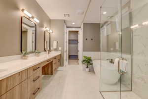 Full bathroom featuring a soaking tub, double vanity, a marble finish shower, a spacious closet, and recessed lighting