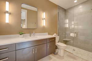 Full bathroom with vanity, a shower stall, light tile patterned floors, and recessed lighting