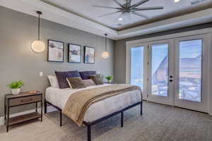 Bedroom featuring french doors, access to outside, a ceiling fan, a raised ceiling, and recessed lighting
