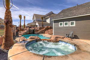 View of pool with a pool with connected hot tub, a patio area, and a water slide