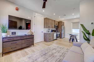 Living room featuring light wood-type flooring, recessed lighting, and a ceiling fan