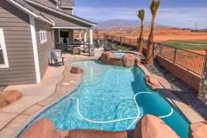 View of swimming pool with a fenced backyard, a patio area, a mountain view, and a pool with connected hot tub