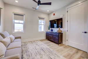 Living room with recessed lighting, light wood-type flooring, and a ceiling fan