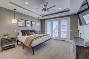 Bedroom featuring a tray ceiling, access to outside, french doors, recessed lighting, and a ceiling fan