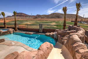 View of swimming pool with a mountain view and a pool with connected hot tub