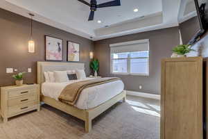 Bedroom with carpet, a tray ceiling, recessed lighting, and ceiling fan