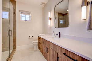 Bathroom with vanity, a stall shower, and light tile patterned flooring