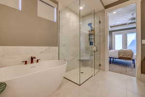 Full bath with a soaking tub, a marble finish shower, ensuite bathroom, tile walls, and tile patterned flooring