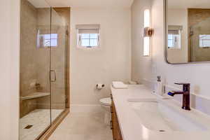 Full bath with vanity, a shower stall, and light tile patterned floors