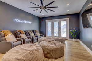 Home theater room with french doors, light wood-type flooring, recessed lighting, and a ceiling fan
