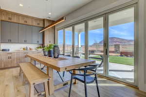 Dining space with a mountain view, light wood-style flooring, and recessed lighting