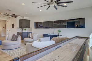 Living area featuring a ceiling fan, recessed lighting, and wood finished floors