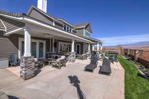 Back of house featuring an outdoor hangout area, a patio, a fenced backyard, outdoor dining space, and a mountain view