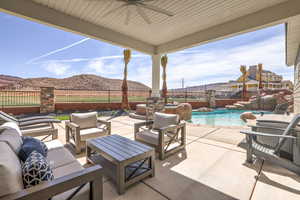 Fenced backyard with a mountain view, a patio, ceiling fan, and an outdoor living space