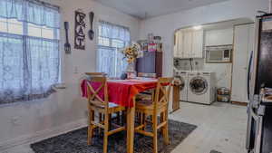 Dining space with light floors, washing machine and clothes dryer, and arched walkways