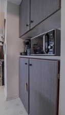 Detailed view of black microwave, stainless steel electric stove, and light countertops
