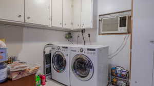 Laundry area with washer and clothes dryer, cabinet space, and a wall mounted air conditioner