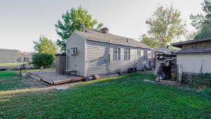 Rear view of house with a wooden deck, a chimney, and a shingled roof