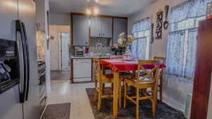 Kitchen featuring stainless steel appliances, light flooring, light countertops, and backsplash