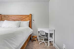 Carpeted bedroom featuring baseboards