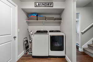 Laundry area featuring dark wood-style flooring and washing machine and clothes dryer