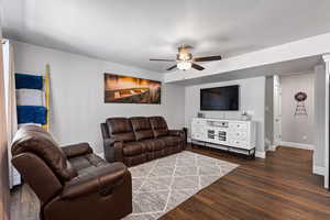 Living room featuring dark wood finished floors and a ceiling fan