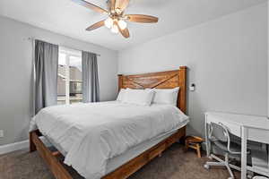 Bedroom featuring dark colored carpet and ceiling fan