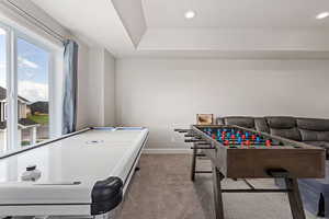 Recreation room featuring light carpet, recessed lighting, and a raised ceiling