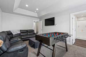 Playroom featuring recessed lighting, a tray ceiling, carpet flooring, and a barn door